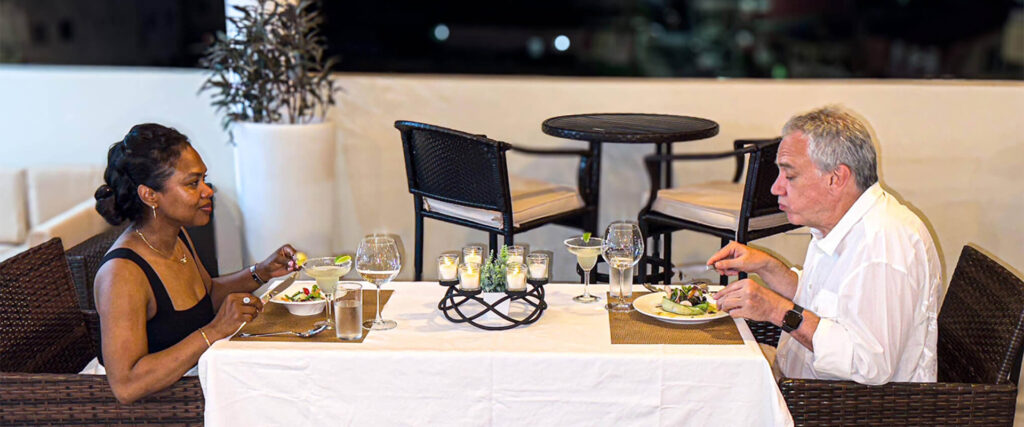 Couple enjoying a romantic dinner in St. Lucia at Felicity Rooftop Restaurant with candlelight and elegant dining setup
