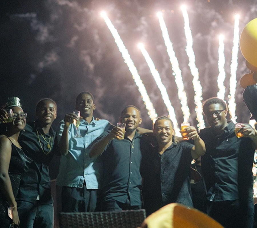 Guests celebrating a private party event in St. Lucia at Felicity Rooftop Restaurant with cocktails and fireworks in the background