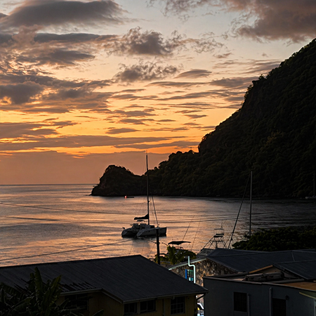 Sunset view over Soufrière St Lucia with sailboats and coastline, showcasing the best dinner restaurant in Soufrière at Felicity Rooftop Restaurant.